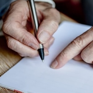 Hände beim Schreiben auf Papier