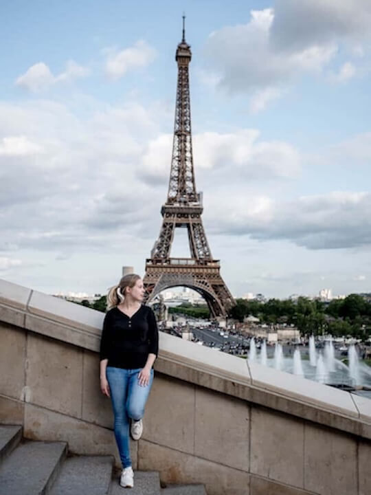 Frau vor dem Eiffelturm in Paris.